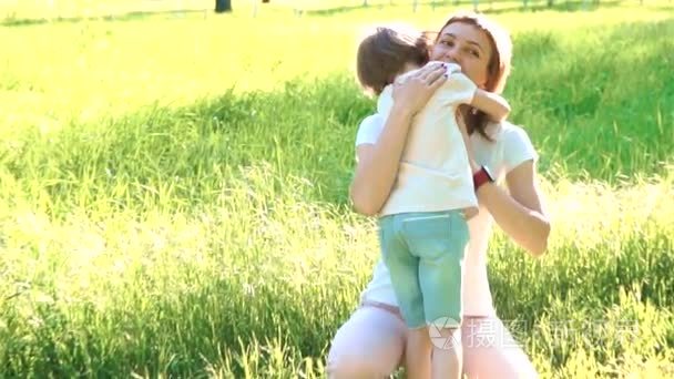 女儿冲进母亲的怀里，给她一个大大的拥抱。在公园外面