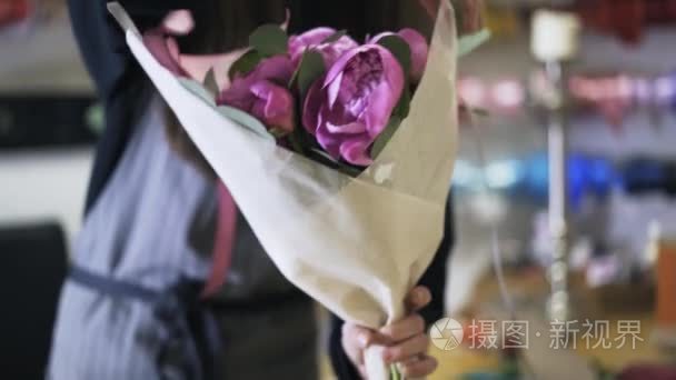 包装一束紫色花的花店营业员视频