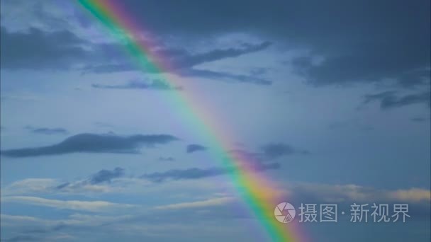 灰色的云层和雨后的彩虹天空。云朵和彩虹天空中缓缓飘落。时间推移镜头