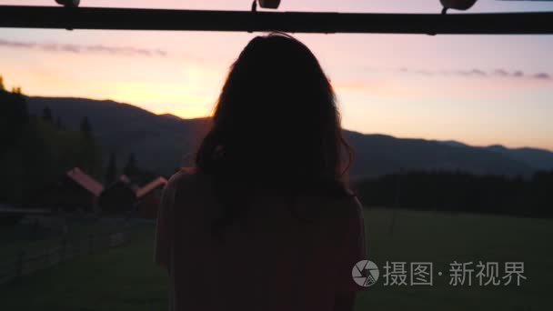 夕阳在山中的背景上的女孩视频