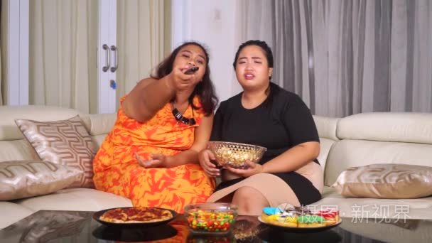 肥胖妇女在沙发上吃垃圾食品视频