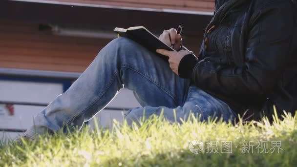 男人的手坐在一片草地，写一篇日记