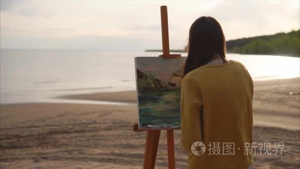 年轻的艺术家绘制的那个女孩是在海洋或河流附近的调色刀静物