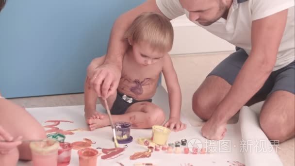 年轻的父亲教他孩子男孩如何画视频