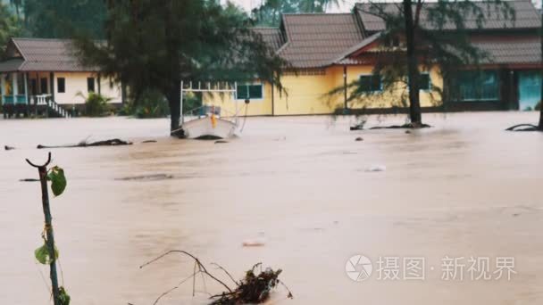 在郊区地区的洪水，黄色房子下水，船押尼珥树，强的雨