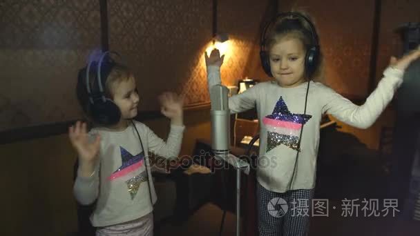 两个小女孩在耳机麦克风在唱歌视频