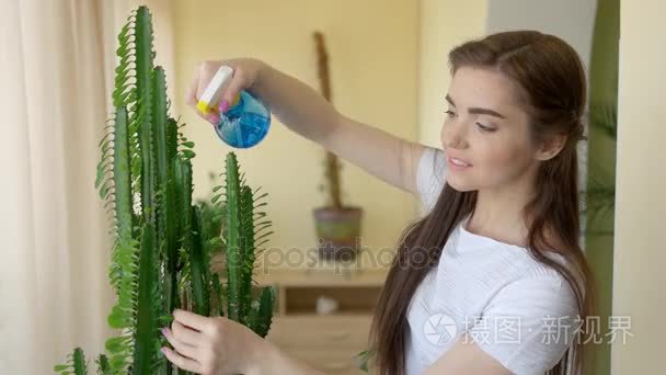年轻女性室内喷洒植物