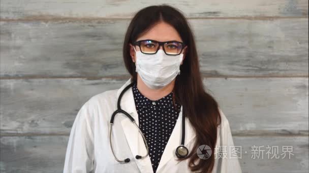 成年女性医生用听诊器在白大衣和防护面具