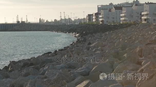 慢全景的石海上建筑物和闸墩在日落灯