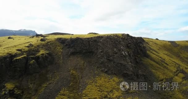 绿色的熔岩场的苔藓覆盖的颠簸的鸟瞰图。无人驾驶飞机飞过山和在冰岛的悬崖