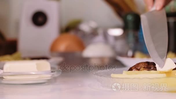 女人用小刀把黄油放在盘子里的食物