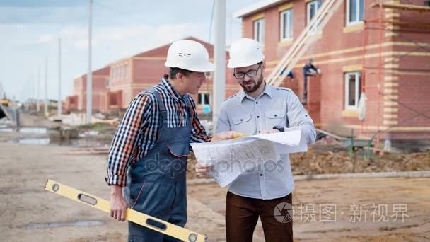 建筑工人在工作的团队。工头和生成器与建设水平