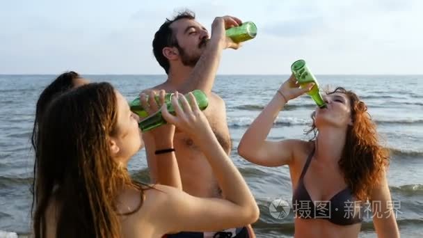 群微笑朋友叮在海滩上的啤酒瓶