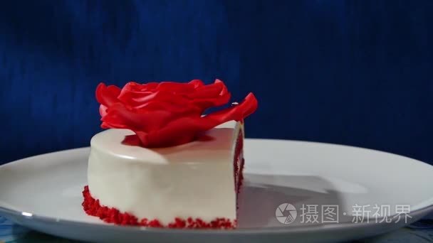 蛋糕和饼干中的上下文是一颗心的形状。红玫瑰制成的蛋糕上的奶油