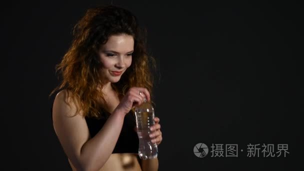 适合女人喝水从瓶子上黑色背景视频