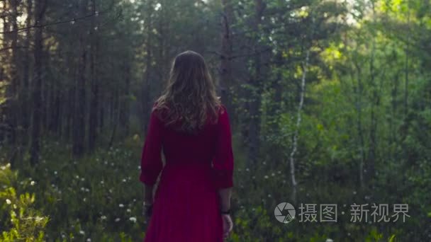 走在森林里的红裙子的年轻女子视频