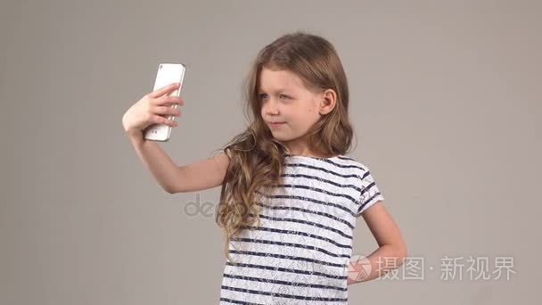 做您的相机手机拍照的小女人。女孩的照片自己在相机手机