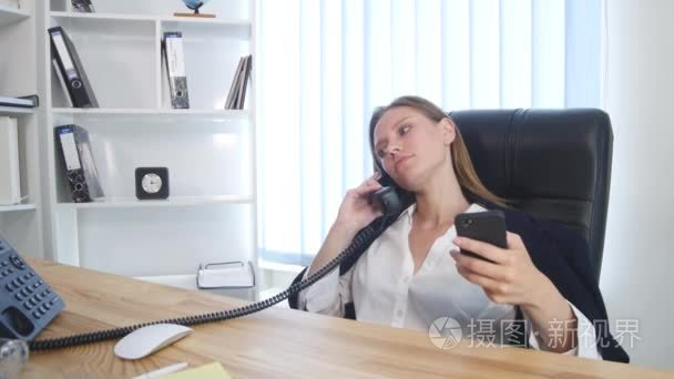 年轻漂亮女商人电话交谈和在办公室使用智能手机和微笑
