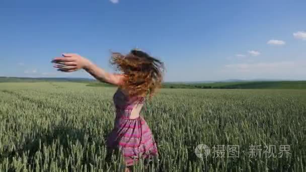 美丽的年轻女子，跳上绿色的麦田