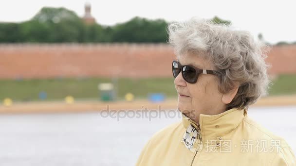 老女人岁 80 年代墨镜看起来站在一边