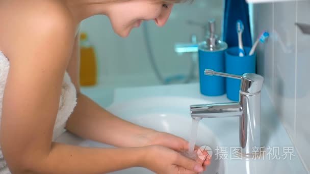 年轻漂亮的女人洗脸在浴室的慢动作镜头