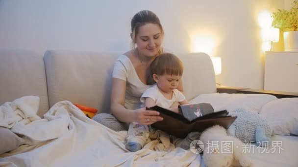 4k 拍摄年轻母亲在睡觉前观看家庭相册照片的画面
