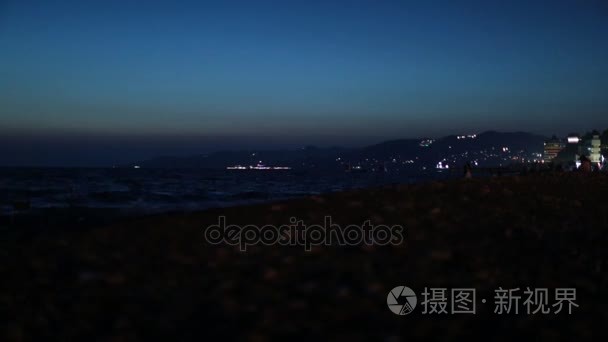 夜海海岸遥远城市的灯光在山视频