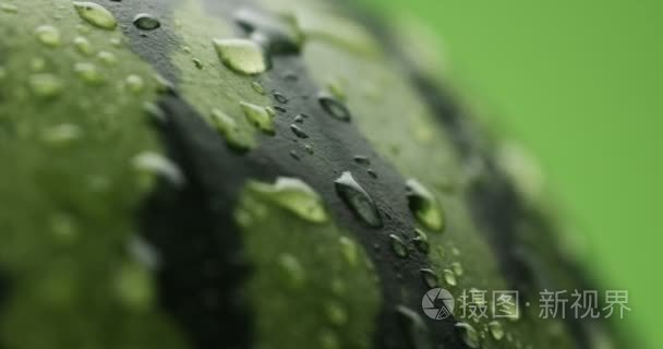 所涵盖的西瓜在绿色背景上旋转的水滴