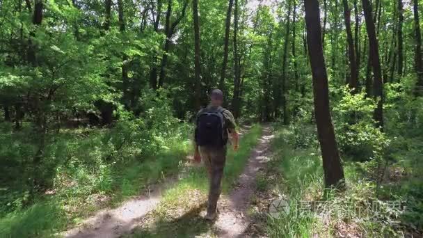 旅游走泥泞小路穿过绿色的森林视频