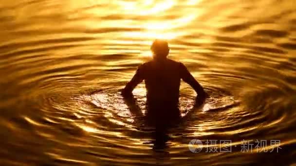 男人自己与大海水倒在夕阳的光视频