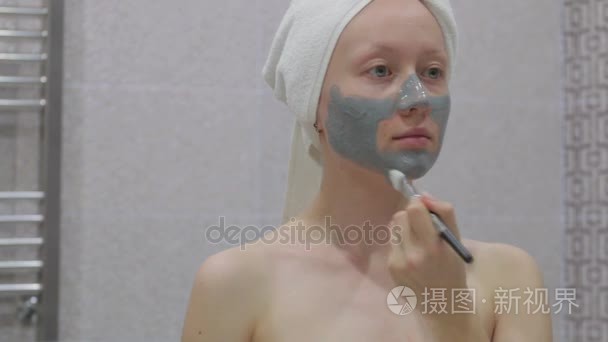 女人在做她脸上的化妆品面膜视频