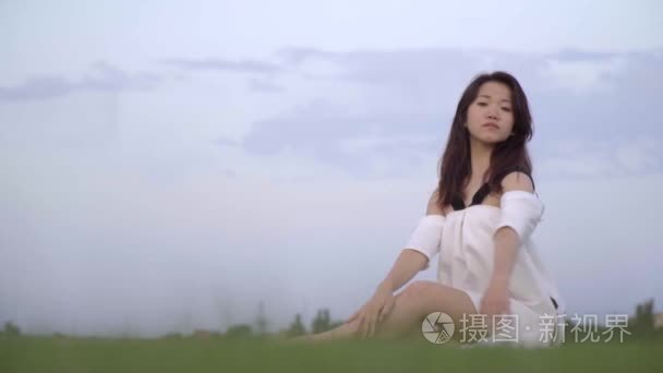 优雅的日本女孩坐在草地上