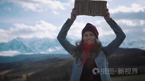 十几岁的女孩在山路、 微笑和大笑一同举行冒险标志