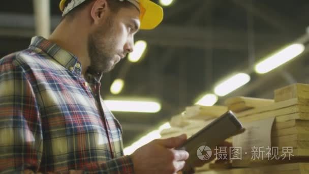 工人数木股票在木材厂仓库使用一台平板电脑视频