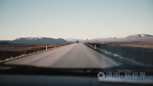 查看与美丽的夕阳，山景观美丽的乡村道路上挡风玻璃车内