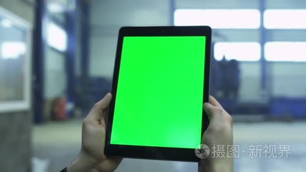 在一家工厂的工业环境中的绿色模拟屏幕平板电脑的画面