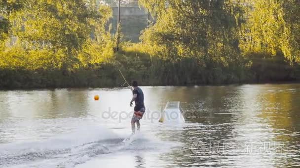 旅人骑在公园里，室外极端慢动作在水中，电缆滑水冲浪运动员上水做 boardslide noseslide 或 tailslid视频