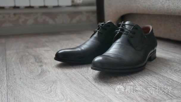 男黑色靴子鞋站在房间的地板上