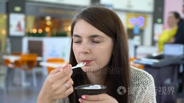 女孩在一家咖啡馆吃果仁巧克力和冰淇淋