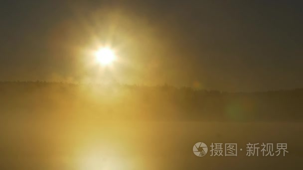 森林湖的夏天日落景色。查看与明亮的太阳湖上遥远的海角和晚霞倒映在平静的水面，在午夜的太阳。雾在月夜河上