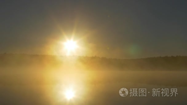 森林湖的夏天日落景色。查看与明亮的太阳湖上遥远的海角和晚霞倒映在平静的水面，在午夜的太阳。雾在月夜河上