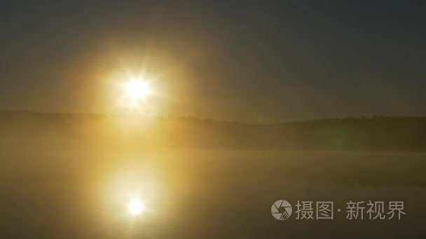 森林湖的夏天日落景色。查看与明亮的太阳湖上遥远的海角和晚霞倒映在平静的水面，在午夜的太阳。雾在月夜河上
