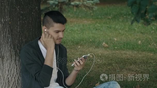 年轻英俊的男人在耳机上听音乐视频