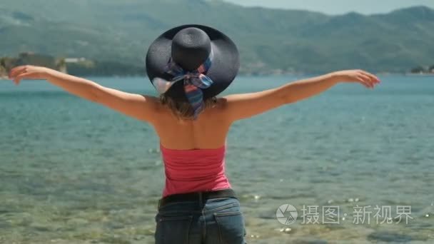 女人在帽子站在岸边愉快地扔到一边的武器