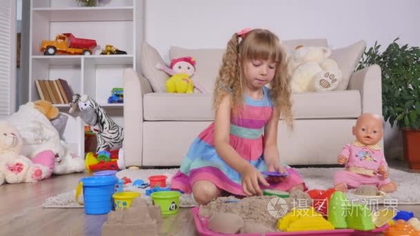 可爱小金发女孩玩沙子在工作室视频