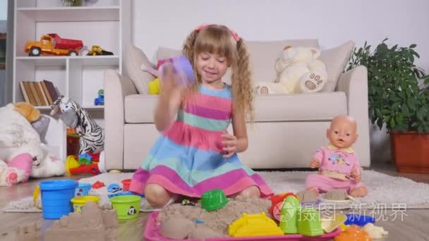 可爱小金发女孩玩沙子在工作室视频