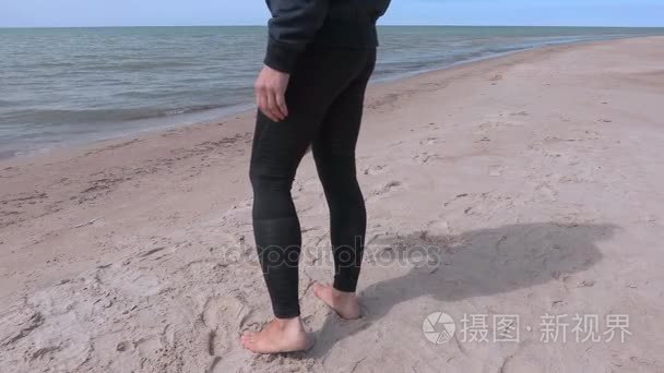 女人光着脚在海滩边上的大海视频