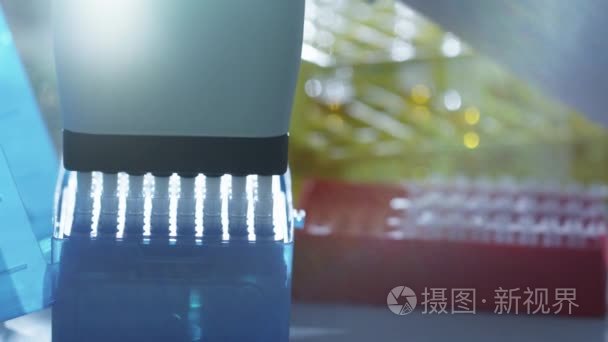 一位科学家，向与微吸管在实验室的试管中添加液体的特写镜头