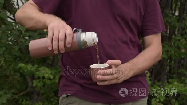 倒进杯子里的茶从保温瓶里倒的男人