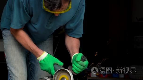 男性中年工人用角磨机切削金属视频